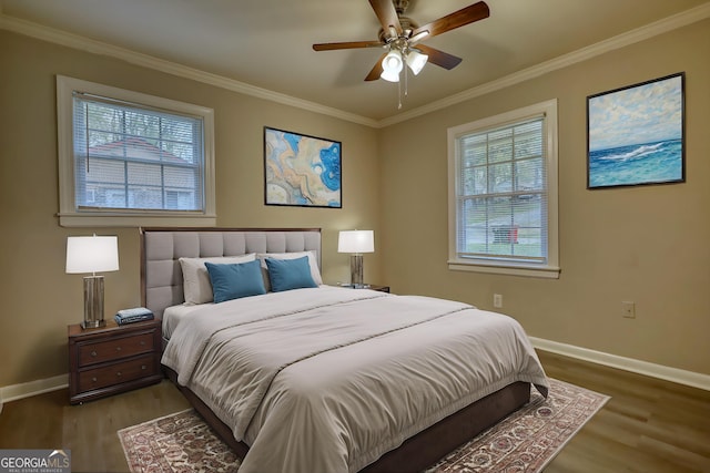 bedroom featuring baseboards, wood finished floors, and crown molding