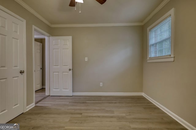 unfurnished room featuring crown molding, baseboards, light wood-type flooring, and a ceiling fan