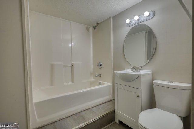 bathroom with  shower combination, a textured ceiling, toilet, and vanity