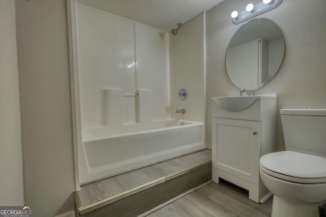 full bath featuring toilet, wood finished floors, vanity, and bathing tub / shower combination