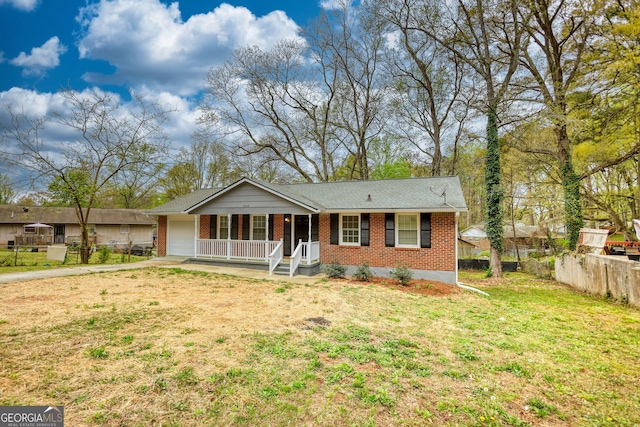 view of front of house with a garage, a front yard, brick siding, driveway, and covered porch