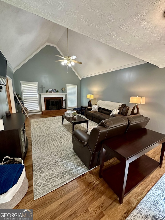 4100 Jewel Rdg, Monroe, GA 30655 - living area with a ceiling fan, lofted ceiling, wood finished floors, and a brick fireplace