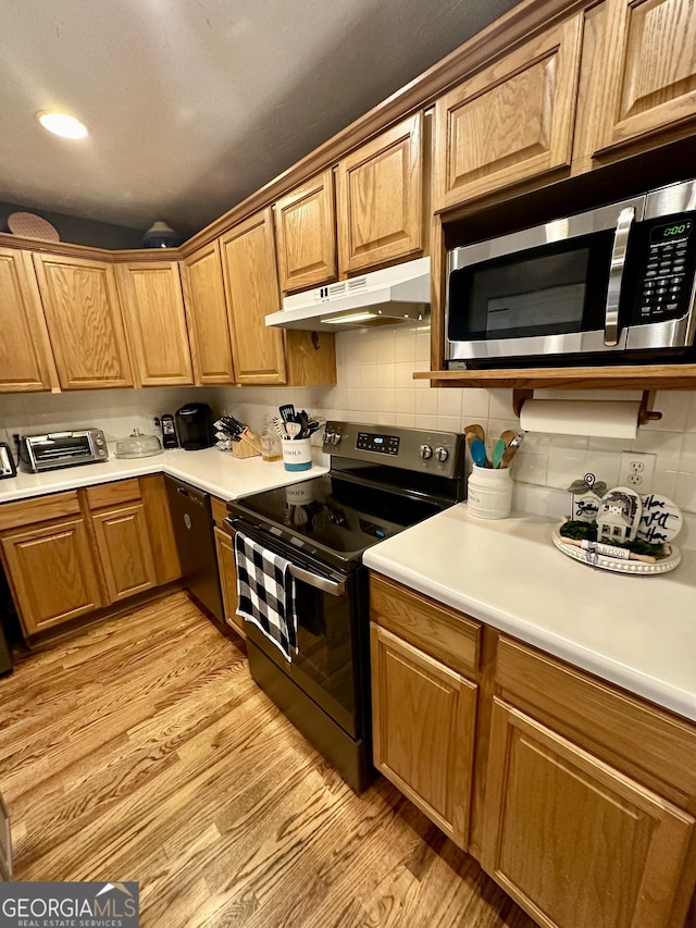 4100 Jewel Rdg, Monroe, GA 30655 - kitchen with black appliances, under cabinet range hood, light wood-style flooring, and backsplash