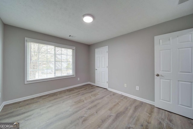 830 Buffington Way, Canton, GA 30115 - unfurnished bedroom featuring baseboards, wood finished floors, visible vents, and a textured ceiling