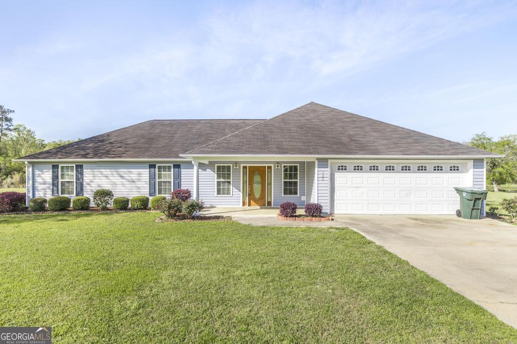 single story home featuring a front lawn, driveway, a shingled roof, and an attached garage