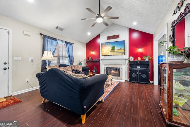 living room featuring a textured ceiling, visible vents, wood finished floors, a ceiling fan, and vaulted ceiling
