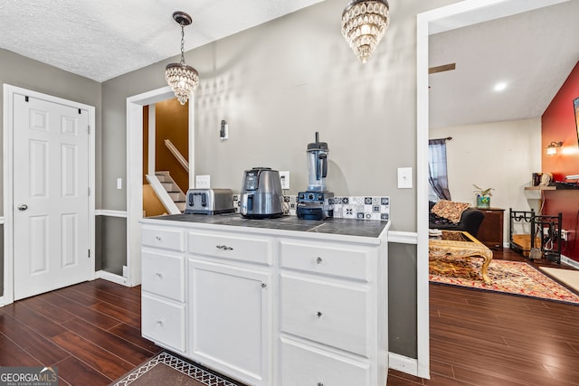 kitchen featuring a chandelier, baseboards, dark wood finished floors, white cabinetry, and tile countertops