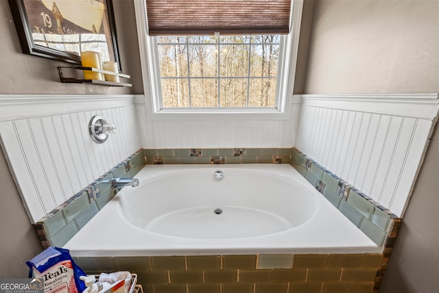full bathroom with a wainscoted wall and a garden tub