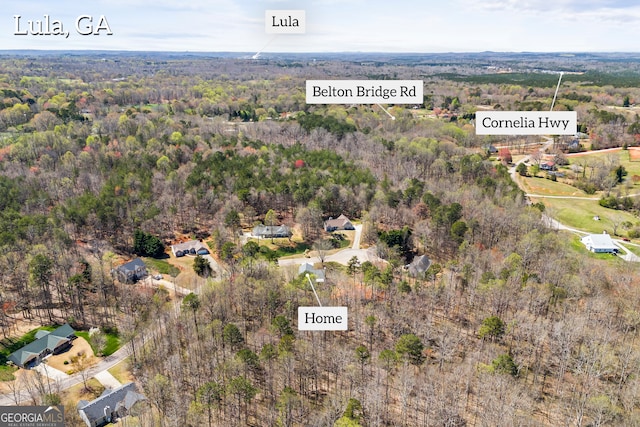 bird's eye view with a wooded view