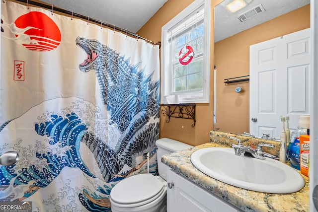 bathroom with vanity, toilet, a textured ceiling, visible vents, and curtained shower