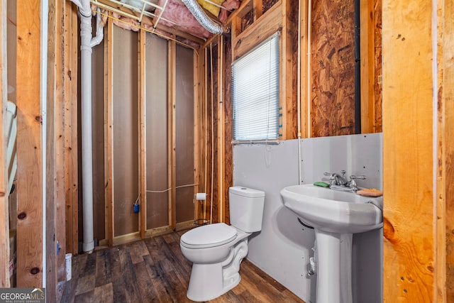 half bath featuring toilet, a sink, and wood finished floors