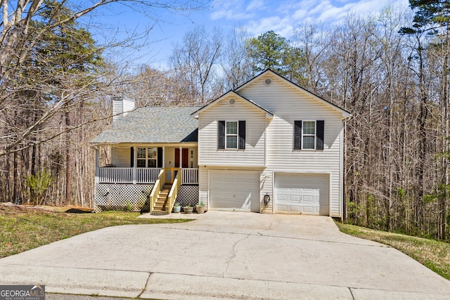 tri-level home with an attached garage, driveway, a porch, a shingled roof, and a chimney