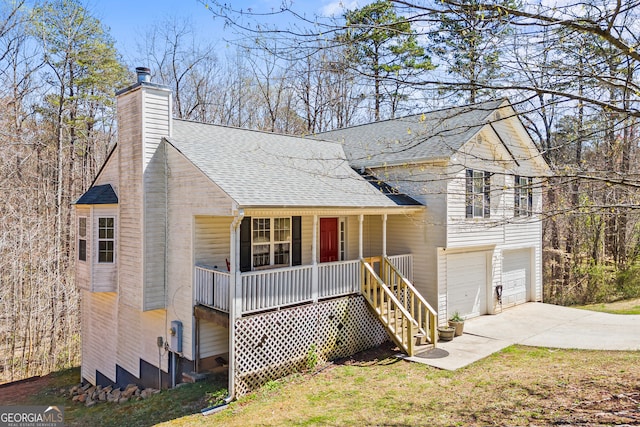 tri-level home with driveway, covered porch, roof with shingles, a chimney, and a garage