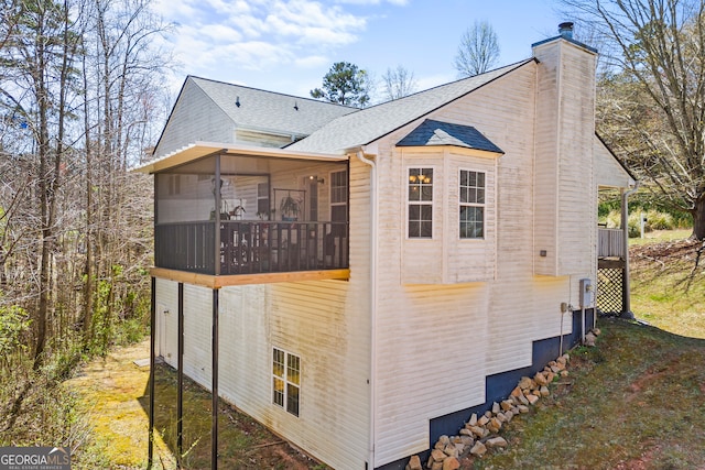 view of property exterior featuring a chimney and roof with shingles
