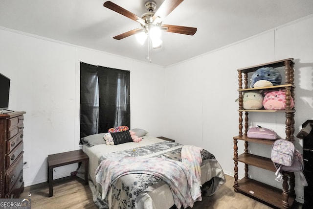 bedroom featuring crown molding, wood finished floors, and ceiling fan