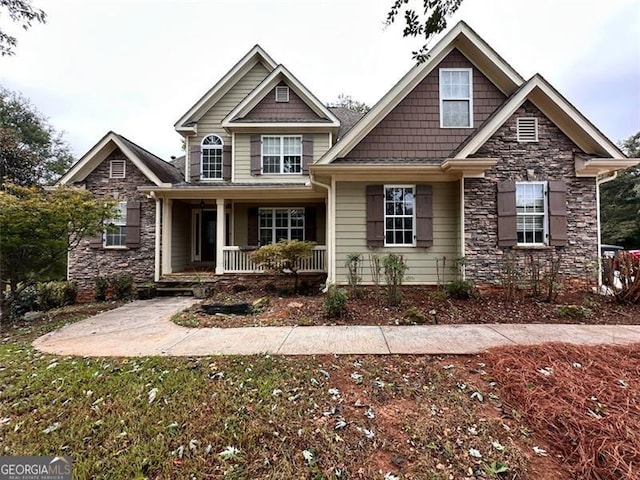 craftsman inspired home featuring covered porch and stone siding