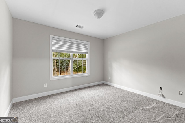 carpeted empty room featuring baseboards and visible vents