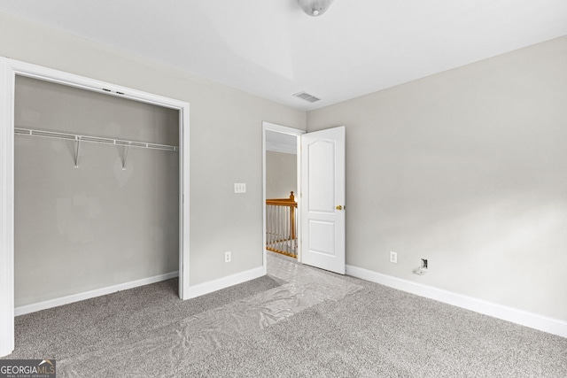 unfurnished bedroom with baseboards, carpet floors, visible vents, and a closet