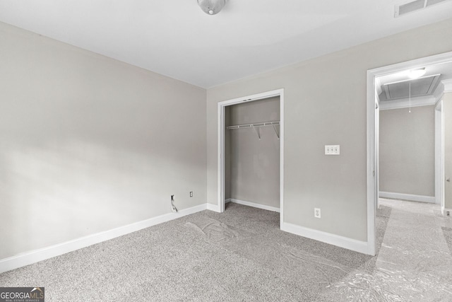 unfurnished bedroom with a closet, carpet flooring, attic access, baseboards, and visible vents