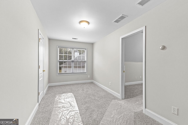 carpeted empty room featuring baseboards and visible vents