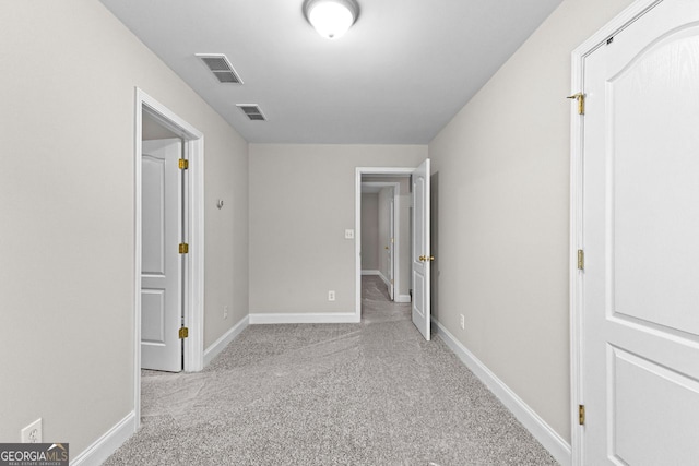 unfurnished bedroom with baseboards, visible vents, and carpet