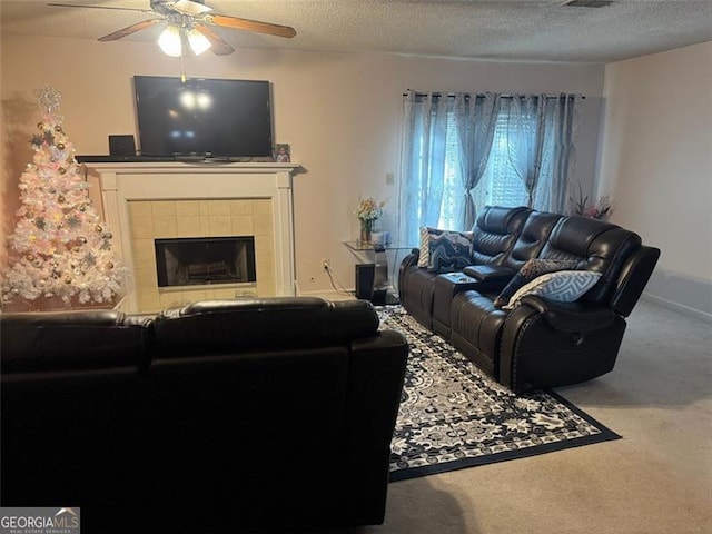 carpeted living area with a textured ceiling, a fireplace, baseboards, and a ceiling fan