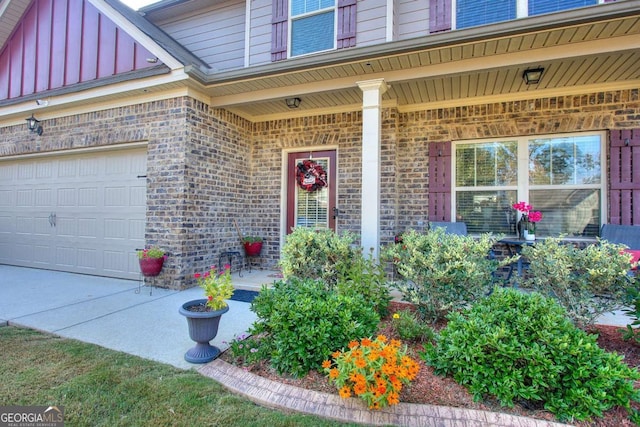 view of exterior entry featuring covered porch and brick siding