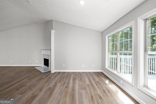 1590 Highland Farm Dr, Suwanee, GA 30024 - unfurnished living room featuring wood finished floors, vaulted ceiling, a high end fireplace, and baseboards