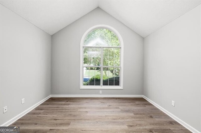 1590 Highland Farm Dr, Suwanee, GA 30024 - unfurnished room featuring wood finished floors, lofted ceiling, and baseboards