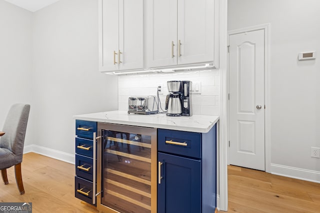 2105 Rotunda Ct, Conyers, GA 30094 - bar featuring baseboards, light wood-style flooring, tasteful backsplash, and beverage cooler