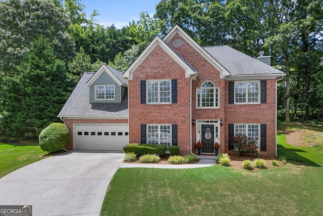 1803 Gold Finch Way, Lawrenceville, GA 30043 - colonial house featuring brick siding, concrete driveway, a front yard, a chimney, and an attached garage