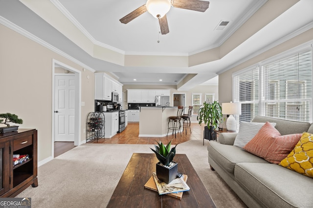 living room featuring baseboards, a ceiling fan, light tile patterned flooring, and ornamental molding