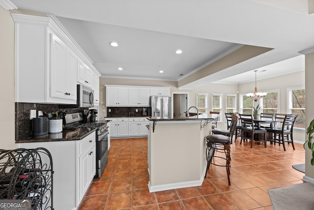 kitchen featuring crown molding, appliances with stainless steel finishes, tile patterned flooring, dark countertops, and tasteful backsplash