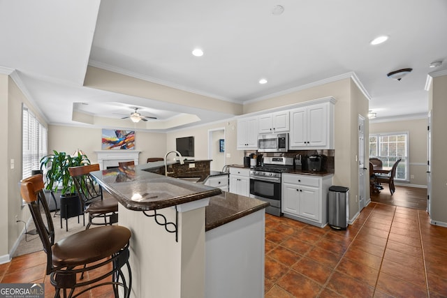 1803 Gold Finch Way, Lawrenceville, GA 30043 - kitchen with appliances with stainless steel finishes, dark countertops, a sink, a breakfast bar, and a ceiling fan