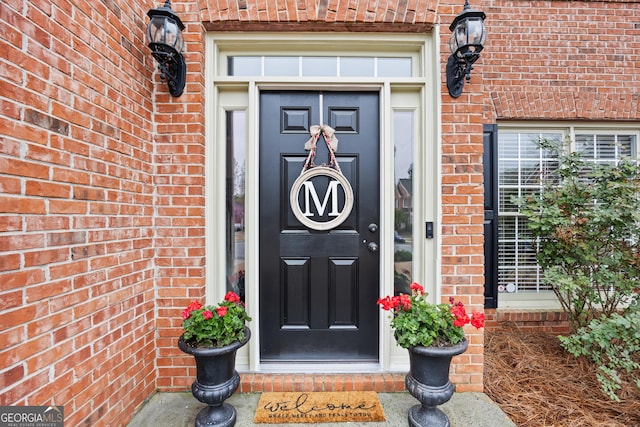 doorway to property featuring brick siding