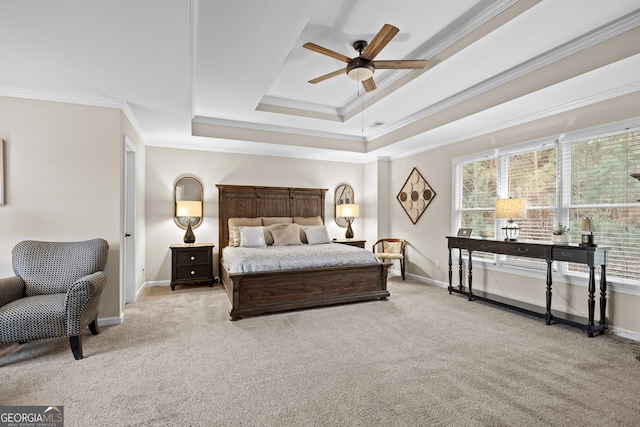 bedroom with ceiling fan, light colored carpet, baseboards, a tray ceiling, and ornamental molding