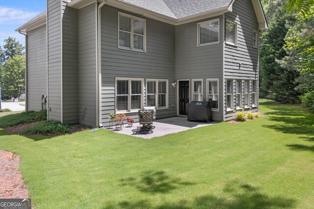 1803 Gold Finch Way, Lawrenceville, GA 30043 - rear view of property featuring a patio area, a lawn, and roof with shingles