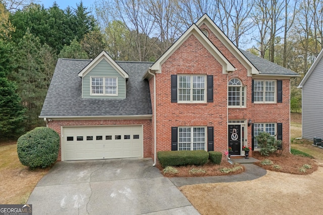 traditional-style house with brick siding, driveway, roof with shingles, and a garage
