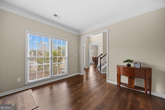 interior space with baseboards, visible vents, ornamental molding, and wood finished floors