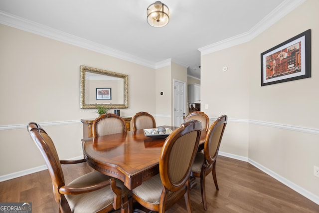 dining area featuring baseboards, ornamental molding, and wood finished floors