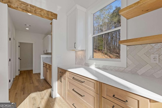 kitchen featuring plenty of natural light, visible vents, tasteful backsplash, and light countertops