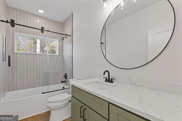 bathroom featuring enclosed tub / shower combo, wood finished floors, toilet, and vanity