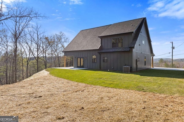 rear view of property with central AC, board and batten siding, a lawn, a shingled roof, and french doors