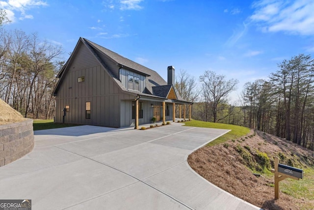 view of side of home with a lawn, a chimney, and board and batten siding