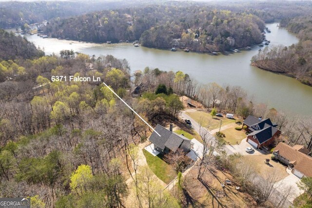 bird's eye view featuring a wooded view and a water view