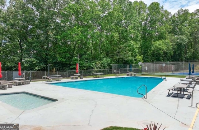 pool with a patio and fence