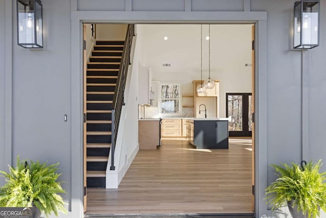 exterior space featuring light countertops, visible vents, wood finished floors, a sink, and open shelves