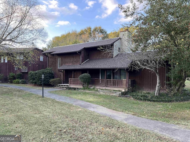view of front of property featuring a front yard, a porch, and a chimney
