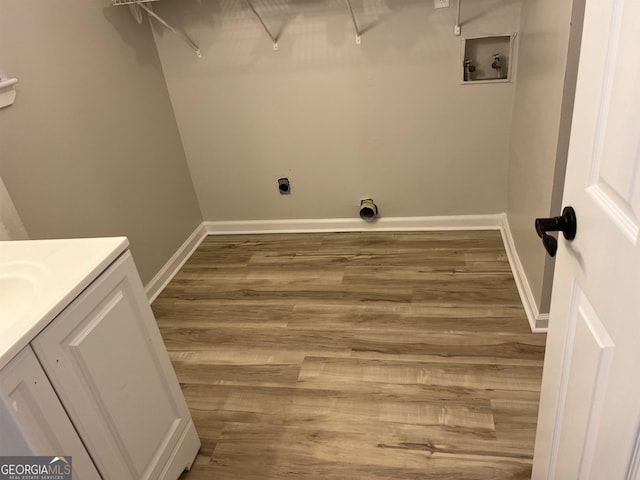 clothes washing area with baseboards, washer hookup, wood finished floors, and electric dryer hookup