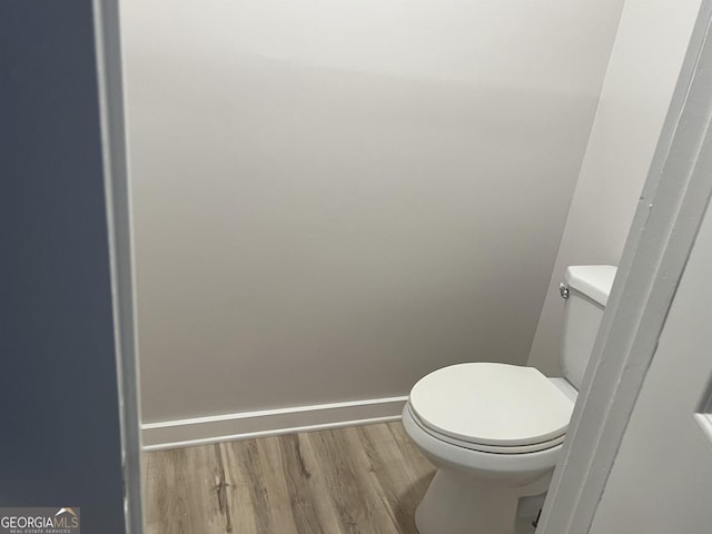 bathroom featuring baseboards, toilet, and wood finished floors